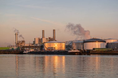 Rotterdam Hollanda 07 Nisan 2020, güneş doğarken Rotterdam limanında tank terminalleri ve kimyasal taşıyıcıları olan petrol limanı