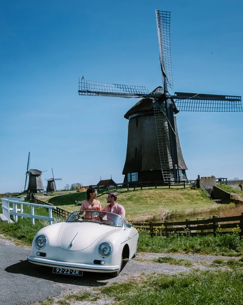 Schermerhorn Alkmaar Netherlands April 2020,. couple doing a road trip with a old vintage sport car White Porsche 356 Speedster, Dutch windmill village Schermerhorn — Stock Photo, Image