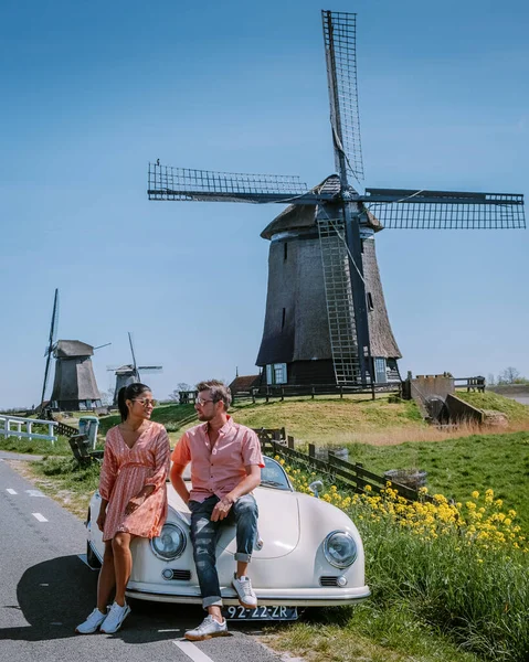 Schermerhorn Alkmaar Netherlands April 2020,. Пара подорожує по дорозі з старовинним спортивним автомобілем White Porsche 356 Speedster, голландським вітровим селом Schermerhorn — стокове фото