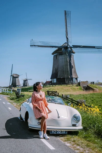 Schermerhorn Alkmaar Netherlands April 2020,. Пара подорожує по дорозі з старовинним спортивним автомобілем White Porsche 356 Speedster, голландським вітровим селом Schermerhorn — стокове фото