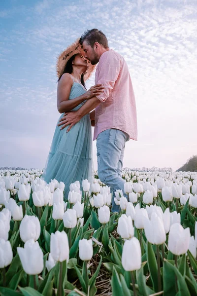 Paar in bloemenveld, tulpen, mannen en vrouw in wit tulpenveld in Nederland — Stockfoto