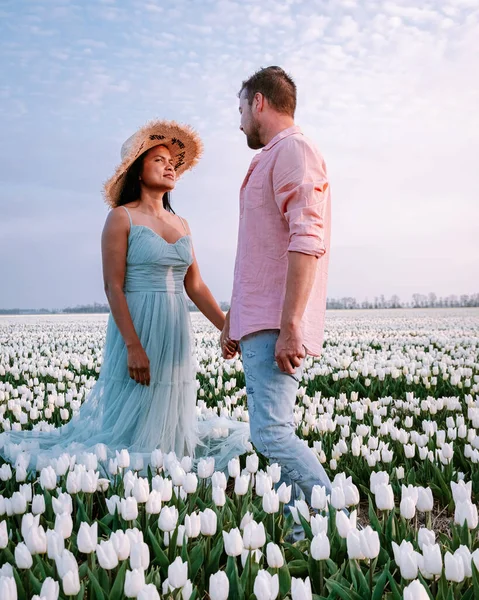 Paar in bloemenveld, tulpen, mannen en vrouw in wit tulpenveld in Nederland — Stockfoto