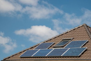 Hollanda 'da güneş panelleri çatıda güneşli bir gökyüzüne bağlı yeni evler inşa edildi. Siyah güneş panellerini kapatın.