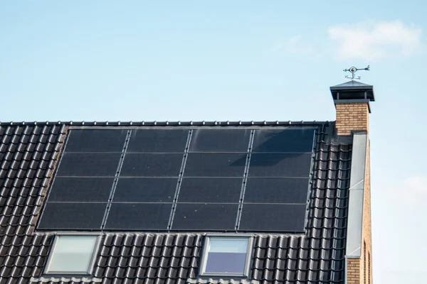 Newly build houses in the Netherlands with solar panels attached on the roof against a sunny sky Close up of new building black solar panels — Stock Photo, Image