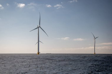 Okyanus açıklarındaki yel değirmeni çiftliği Westermeerwind Parkı 'ndaki yel değirmenleri Hollanda Flevoland Noordoostpolder' ın güneşli bir gününde denizde izole edilmiş.