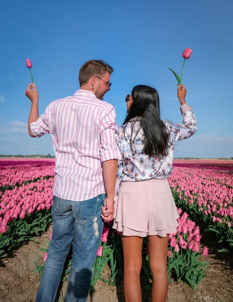 Tulpenvelden in Nederland, paar mannen en vrouwen in bloemenveld in het voorjaar in Nederland — Stockfoto