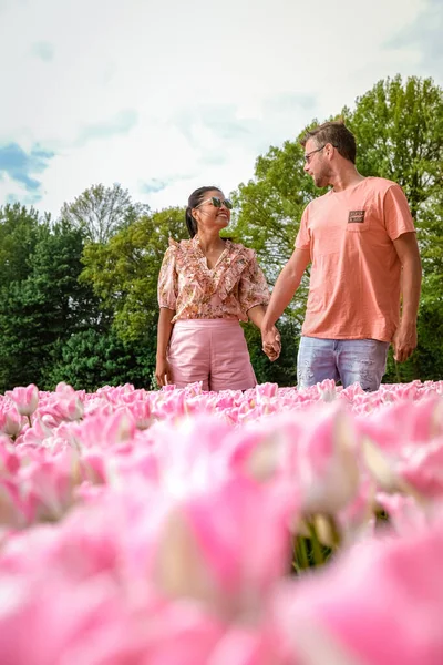 Тюльпановые поля в Нидерландах, пара мужчин и женщин на цветочном поле весной в Нидерландах — стоковое фото