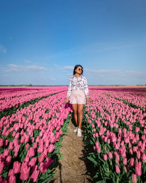 Çiçek tarlasında bir kadın, Hollanda 'da lale tarlasında genç bir kız açık güneşli bir bahar gününde — Stok fotoğraf