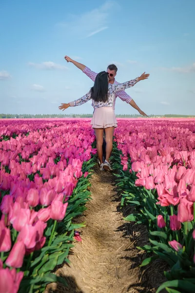 Tulipánová pole v Nizozemsku, pár mužů a žen na poli květin během jara v Nizozemí — Stock fotografie