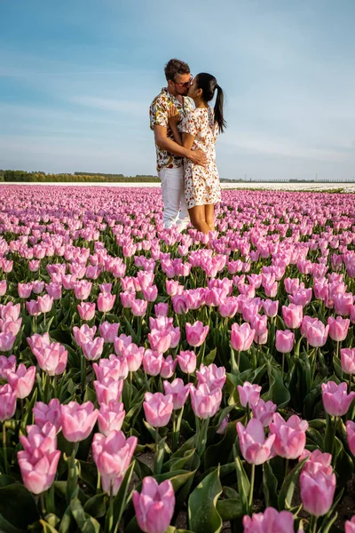 Champs de tulipes aux Pays-Bas, deux hommes et une femme dans un champ de fleurs au printemps aux Pays-Bas — Photo