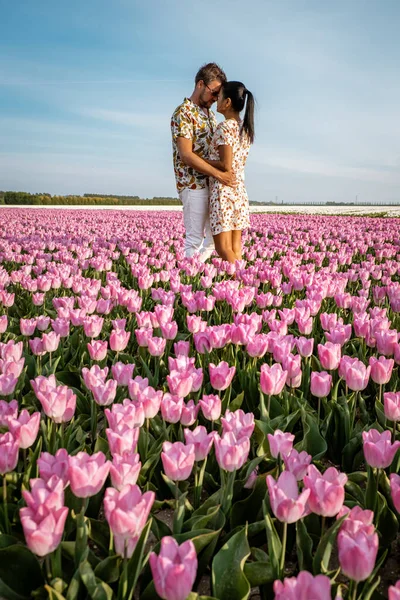 네덜란드의 튤립 밭, 네덜란드의 봄철에 꽃 밭에서 꽃을 피우고 있는 남녀 — 스톡 사진