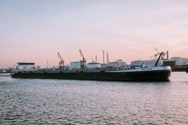 Rotterdam Limanı Hollanda Nisan 2020, güneş batarken limanda petrol tankerli gaz ve petrol depolama tankları