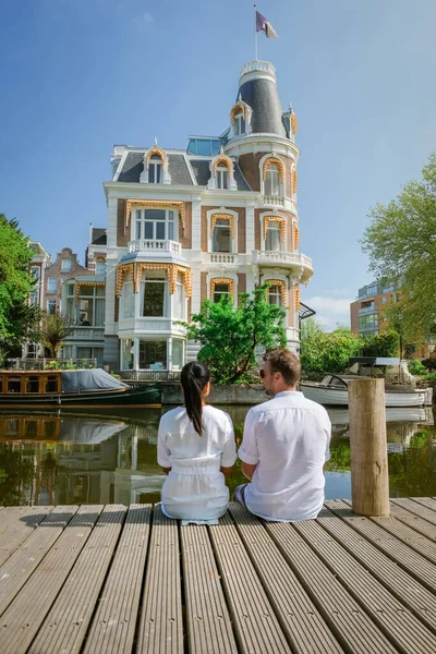 Amsterdam 'a şehir gezisine çıkan çift, 2020 ilkbaharında Amsterdam kanallarında dinlenen erkek ve kadın Avrupa' da Hollanda 'da — Stok fotoğraf
