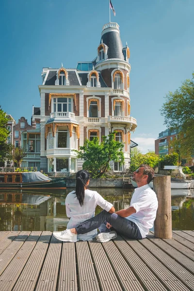 Амстердам Нидерланды исторический центр, мужчины и женщины во время поездки весной 2020 года, пара посетить город Амстердам во время вспышки вируса Корона Ковид 19 , — стоковое фото
