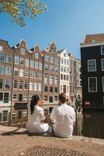 Amsterdam Netherlands city historical center, men and woman on city trip during Spring 2020, couple visit the city of Amsterdam during the outbreak of Corona virus Covid 19,