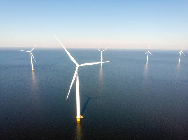 ノードストッポルダーのオランダでカラフルなチューリップ畑を持つ風車農場、海と土地で緑のエネルギー風車 — ストック写真