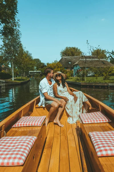 Giethoorn Hollandalı çift, sıcak bir bahar günü çiftlikte, kanallı ve sazdan çatı evleriyle ünlü köy manzaralı bir tekneyle köyü ziyaret ediyor. — Stok fotoğraf