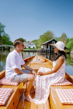 Giethoorn Hollandalı çift, sıcak bir bahar günü çiftlikte, kanallı ve sazdan çatı evleriyle ünlü köy manzaralı bir tekneyle köyü ziyaret ediyor.