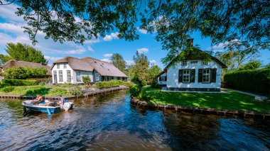 GIETHOORN, NETHERLANDS Mayıs 2020 tipik Giethoorn evleri Mayıs 2020 'de Hollanda, Giethoorn' da görülmektedir. Güzel evler ve bahçıvanlık şehri kuzeyin Venedik 'i olarak bilinir.