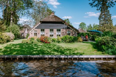GIETHOORN, NETHERLANDS Mayıs 2020 tipik Giethoorn evleri Mayıs 2020 'de Hollanda, Giethoorn' da görülmektedir. Güzel evler ve bahçıvanlık şehri kuzeyin Venedik 'i olarak bilinir.
