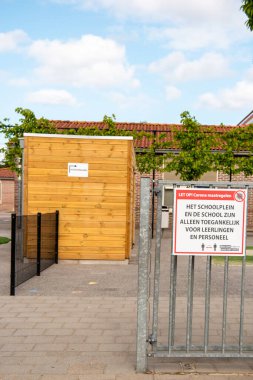 Urk Hollanda 11 Mayıs 2020, Covid19 virüsü sırasında korona kapatıldıktan sonra okullar tekrar açıldı. Çocukları okula bırakırken ebeveyn kuralları ile okul önünde imza atın.