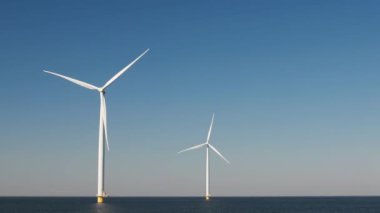 Hollanda 'daki yel değirmeni çiftliği, yel değirmeni türbini çiçekleri ve arazide çalışan çiftçiler, Hollanda' da yeşil enerji.