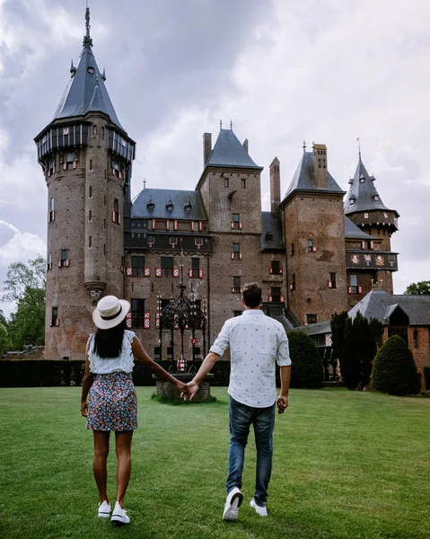 Пара чоловіків і жінок відвідують замок в Нідерландах, замок де Хаар Нідерланди Утрехт на яскравому молодому парі чоловіків і жінка середнього віку, що йдуть в сад замку. — стокове фото