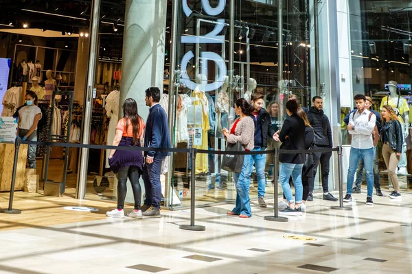 Utrecht Netherlands May 23 2020, shopping mall Hoog Catharijne on a bussy weekend day during the coronavirus outbreak with people waiting in lines on 1,5 meter distance to enter the shop save. — Stock Photo, Image