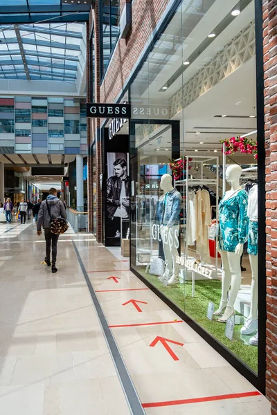 Utrecht Netherlands May 23 2020, shopping mall Hoog Catharijne on a bussy weekend day during the coronavirus outbreak with people waiting in lines on 1,5 meter distance to enter the shop save. — Stock Photo, Image