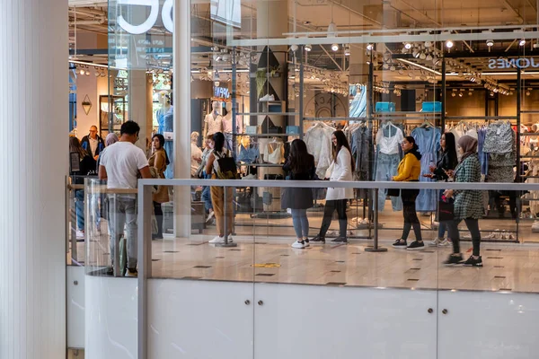 Utrecht Netherlands May 23 2020, shopping mall Hoog Catharijne on a bussy weekend day during the coronavirus outbreak with people waiting in lines on 1,5 meter distance to enter the shop save. — Stock Photo, Image
