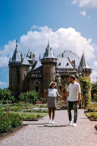 Παλιό ιστορικό κάστρο κήπο, Castle de Haar Ολλανδία Ουτρέχτη σε μια φωτεινή καλοκαιρινή ημέρα, νέοι άνδρες ζευγάρι και γυναίκα μέσης ηλικίας περπάτημα στον κήπο κάστρο — Φωτογραφία Αρχείου