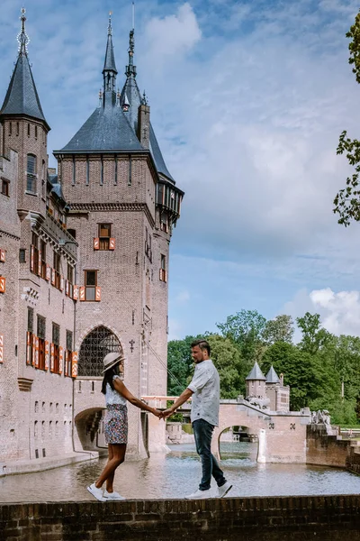 couple relaxing in castle garden ,old historical castle garden,Castle de Haar Netherlands Utrecht on a bright summer day, young couple men and woman mid age walking in the castle garden