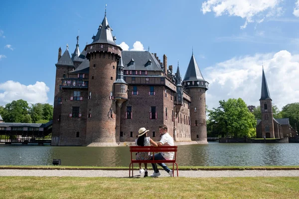 Старый исторический сад замка, замок де Хаар Нидерланды Утрехт в яркий летний день, молодая пара мужчин и женщин среднего возраста прогулки в саду замка — стоковое фото