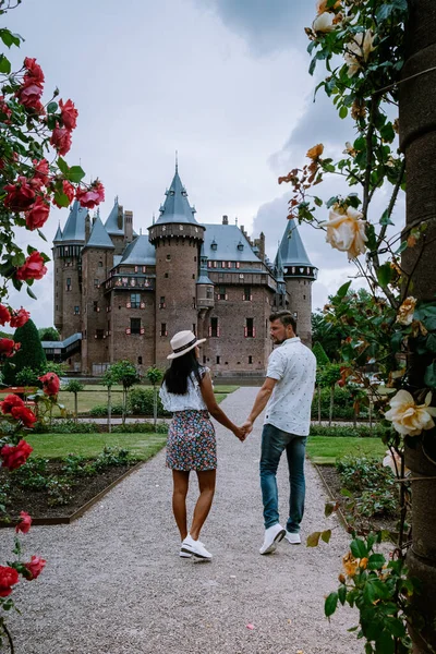 Viejo jardín histórico del castillo, Castillo de Haar Países Bajos Utrecht en un día de verano brillante, joven pareja de hombres y mujeres de mediana edad caminando en el jardín del castillo — Foto de Stock