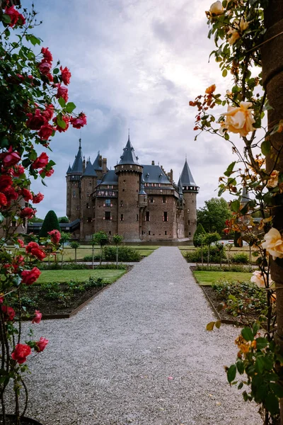 Viejo jardín histórico en el Castillo de Haar Países Bajos Utrecht en un día de verano brillante, joven pareja de hombres y mujeres de mediana edad caminando en el jardín del castillo — Foto de Stock