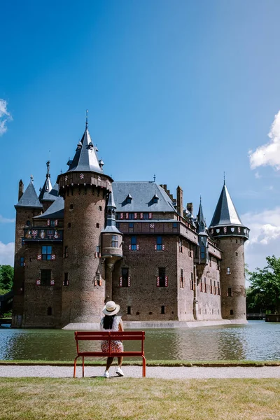 Viejo jardín histórico del castillo, Castillo de Haar Países Bajos Utrecht en un día de verano brillante, mujer joven de mediana edad caminando en el jardín del castillo — Foto de Stock