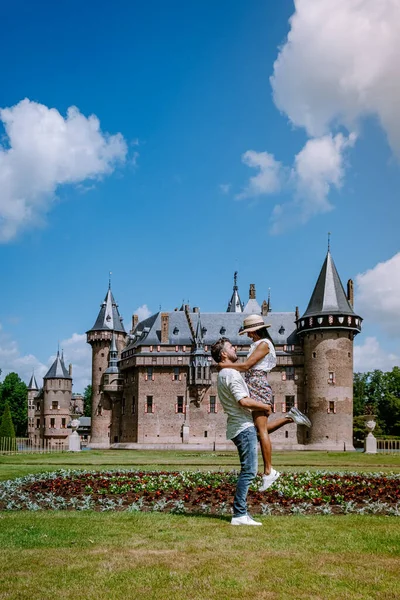 Viejo jardín histórico del castillo, Castillo de Haar Países Bajos Utrecht en un día de verano brillante, joven pareja de hombres y mujeres de mediana edad caminando en el jardín del castillo — Foto de Stock