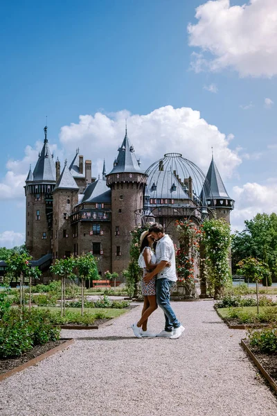 Viejo jardín histórico del castillo, Castillo de Haar Países Bajos Utrecht en un día de verano brillante, joven pareja de hombres y mujeres de mediana edad caminando en el jardín del castillo — Foto de Stock