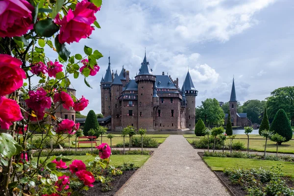 Viejo jardín histórico en el Castillo de Haar Países Bajos Utrecht en un día de verano brillante, joven pareja de hombres y mujeres de mediana edad caminando en el jardín del castillo —  Fotos de Stock