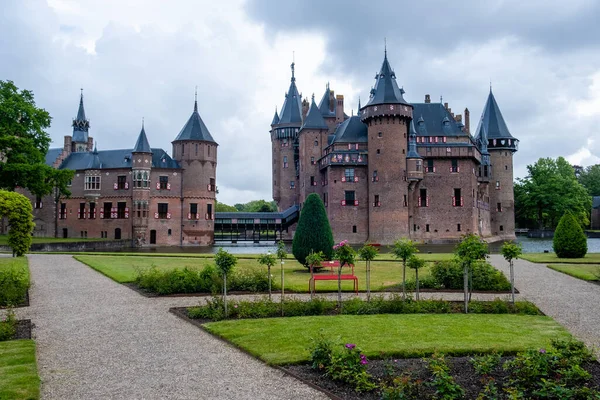 Gammal historisk trädgård på Castle de Haar Nederländerna Utrecht på en ljus sommardag, unga par män och kvinna medelåldern promenader i slottsträdgården — Stockfoto