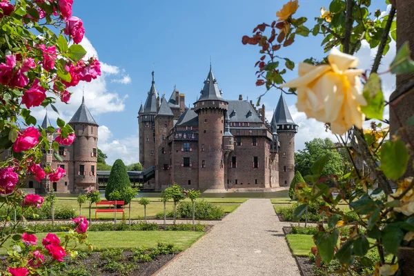 Viejo jardín histórico en el Castillo de Haar Países Bajos Utrecht en un día de verano brillante, joven pareja de hombres y mujeres de mediana edad caminando en el jardín del castillo — Foto de Stock