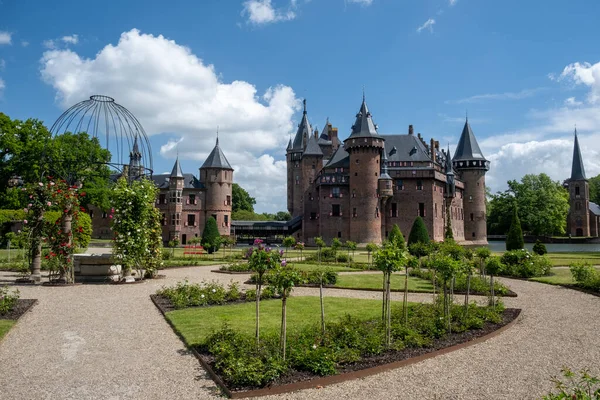 Viejo jardín histórico en el Castillo de Haar Países Bajos Utrecht en un día de verano brillante, joven pareja de hombres y mujeres de mediana edad caminando en el jardín del castillo — Foto de Stock