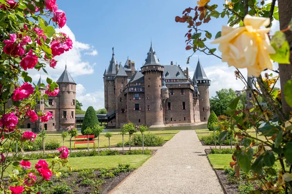 Gammal historisk trädgård på Castle de Haar Nederländerna Utrecht på en ljus sommardag, unga par män och kvinna medelåldern promenader i slottsträdgården — Stockfoto