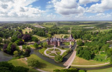 Hollanda Kalesi 'ndeki eski tarihi bahçe. Parlak bir yaz gününde genç bir çift ve erkek kale bahçesinde yürüyorlar.