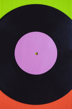 Yukarıdan görülen kırmızı ve yeşil arka planda siyah vinil.