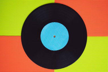 Yukarıdan görülen kırmızı ve yeşil arka planda siyah vinil.