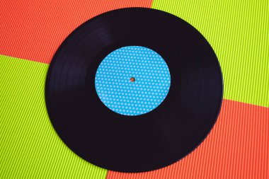 Yukarıdan görülen kırmızı ve yeşil arka planda siyah vinil.