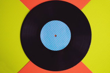 Yukarıdan görülen kırmızı ve yeşil arka planda siyah vinil.