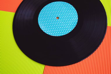 Yukarıdan görülen kırmızı ve yeşil arka planda siyah vinil.