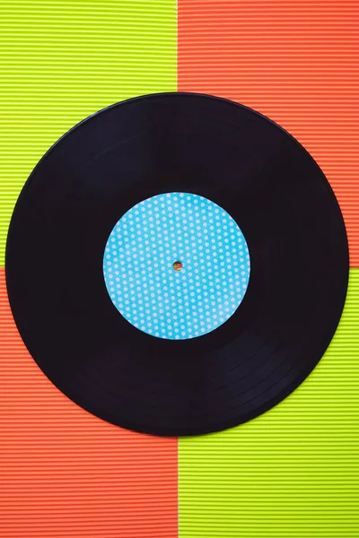 Černý Vinyl Uspořádány Červeném Zeleném Pozadí Vidět Shora — Stock fotografie